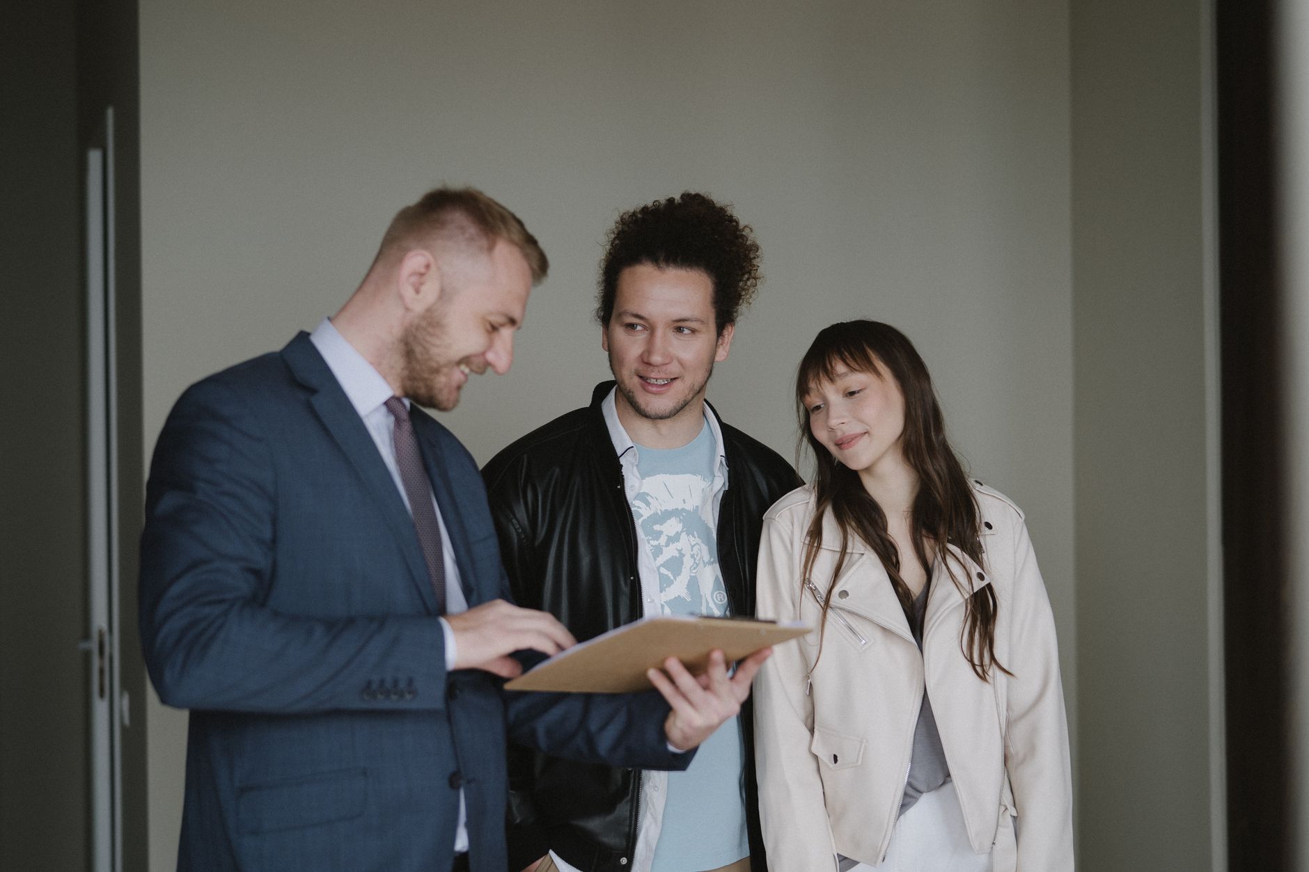 Happy couple meeting with a real estate agent discussing paperwork indoors.